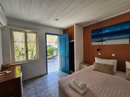 a bedroom with a bed and a blue door at Kirki Hydra in Hydra