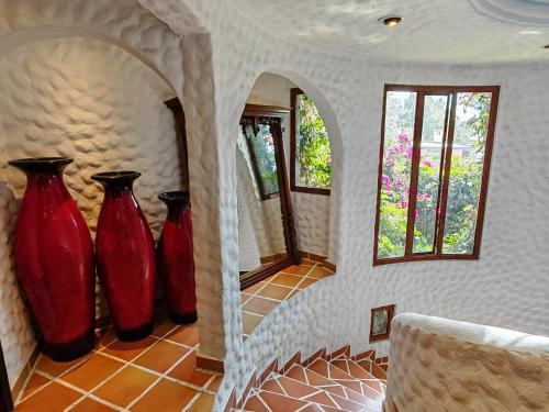 a row of red vases sitting on a wall at Mansion Tepotzotlan in Tepotzotlán
