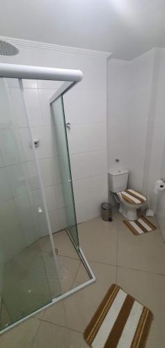 a bathroom with a glass shower and a toilet at Praia do Gonzaguinha em São Vicente in São Vicente