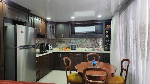 cocina con mesa y nevera de acero inoxidable en Luxury 3 Bedroom Apartment, en Puerto Limón