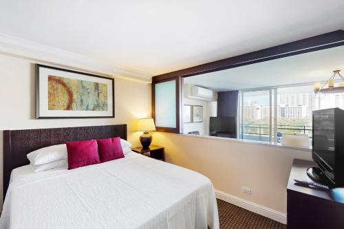 a bedroom with a bed and a large window at The Regency at Beachwalk - Unit 93 in Honolulu