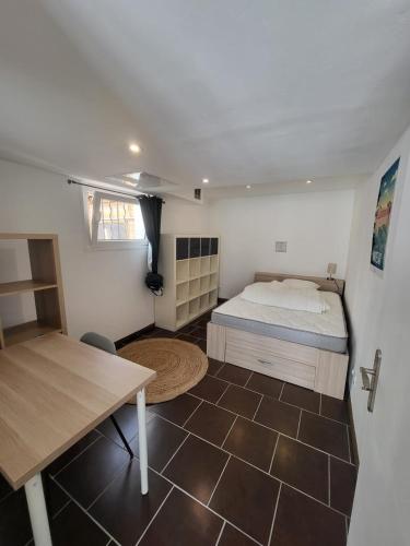 a small bedroom with a bed and a table at L'agréable in Nantes