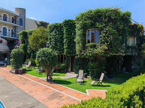 a garden with chairs and trees and a building at Mansion Tepotzotlan in Tepotzotlán