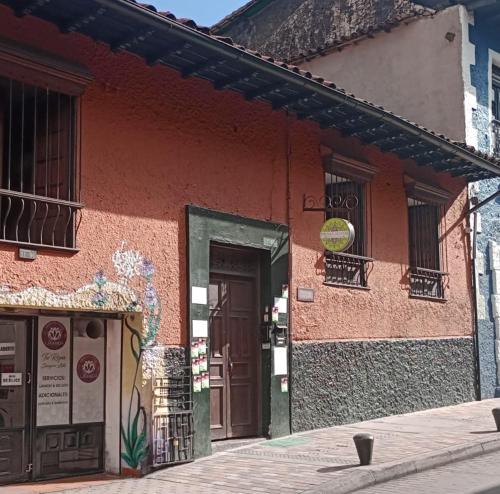 a red building with a door in a street at Prisma Hostel in Bogotá