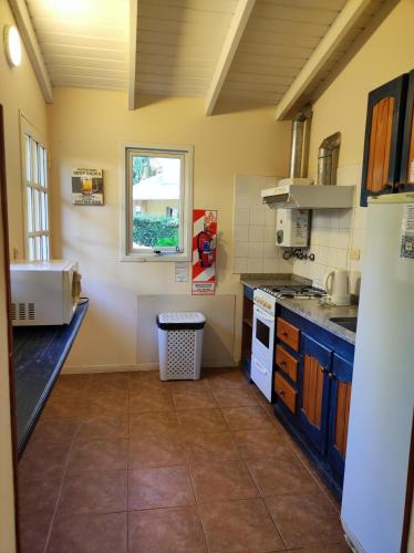 a large kitchen with a sink and a window at Las Terrazas Resort & Apart-Cabañas in La Falda