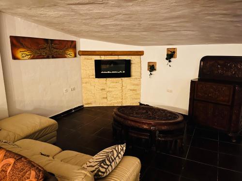 sala de estar con sofá y chimenea en Pintadera house Vulcano, en Icod de los Vinos
