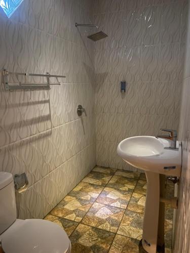 ein Badezimmer mit Waschbecken und Toilette in der Unterkunft Pucuk Bali Homestay in Canggu