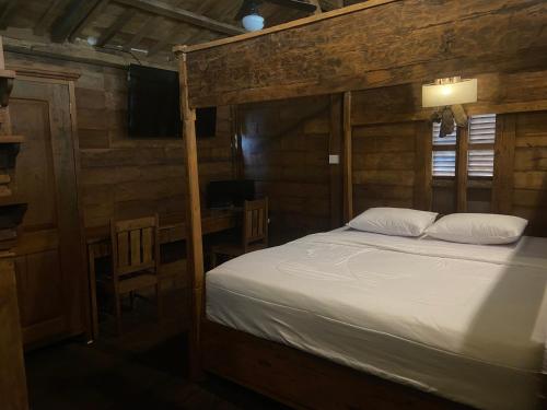ein Schlafzimmer mit einem Bett mit weißen Laken und Kissen in der Unterkunft Pucuk Bali Homestay in Canggu