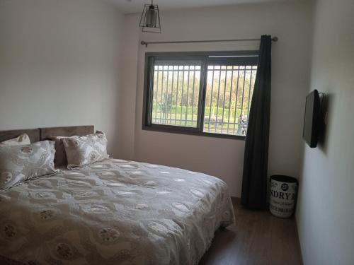 1 dormitorio con cama y ventana en Studio neuf meublé donnant sur la forêt de nouaceur, en Nouaceur