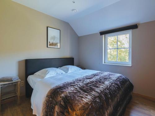 Un dormitorio con una cama grande y una ventana en Beautiful villa in Durbuy, en Durbuy