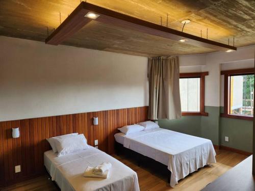 sypialnia z 2 łóżkami i 2 oknami w obiekcie Apartamentos da Rota w mieście Domingos Martins