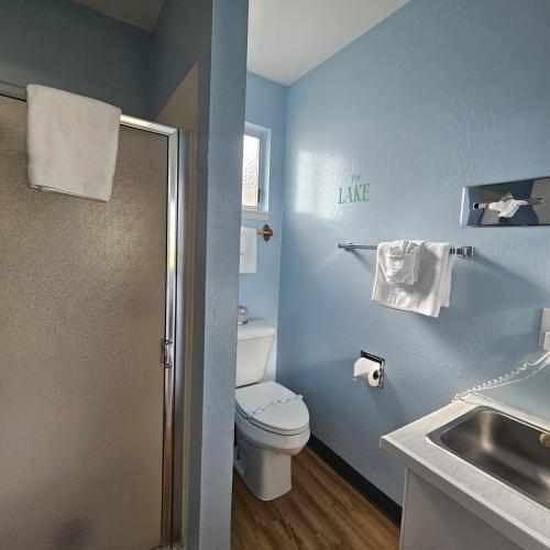a blue bathroom with a toilet and a sink at Skylark Shores Resort in Lakeport