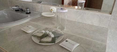 a bathroom with a sink and a glass plate on a counter at Hotel Viña del Sur in Tarija