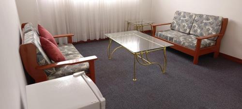 a room with a couch and a table and chairs at Hotel Viña del Sur in Tarija