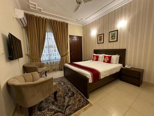 ein Hotelzimmer mit einem Bett und einem Stuhl in der Unterkunft Margalla Hills Residency Islamabad Guest House in Islamabad