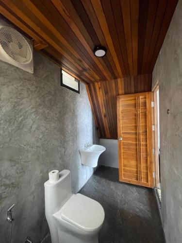 a bathroom with a toilet and a sink at Dugong Koh Sukorn in Ko Sukon