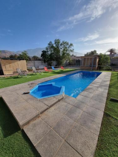 a swimming pool in a yard with a grass field at Cabañas Sol de Vicuña in Vicuña