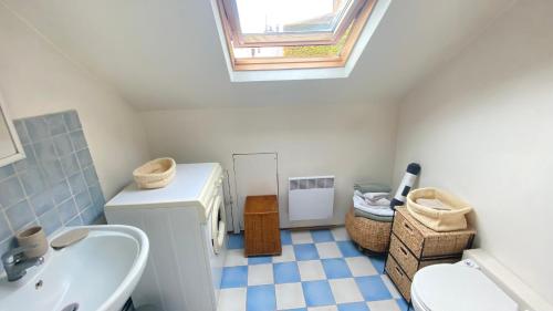 uma casa de banho com um lavatório, um WC e uma clarabóia em Charmant studio parisien em Paris
