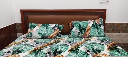 - un lit avec 2 oreillers et un couvre-lit avec des feuilles de palmier dans l'établissement HOTEL RIO, à Sirhind