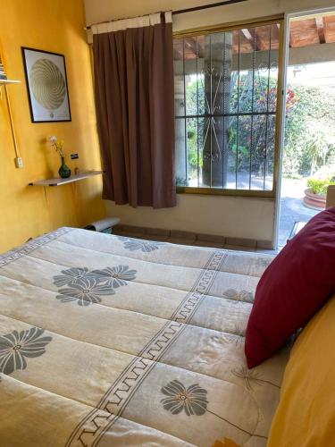 Schlafzimmer mit einem großen Bett und einem Fenster in der Unterkunft Quinta Ángeles in Cuernavaca