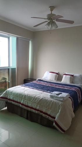 um quarto com uma cama grande e uma ventoinha de tecto em 2 habitaciónes vista al río 102 em Guayaquil