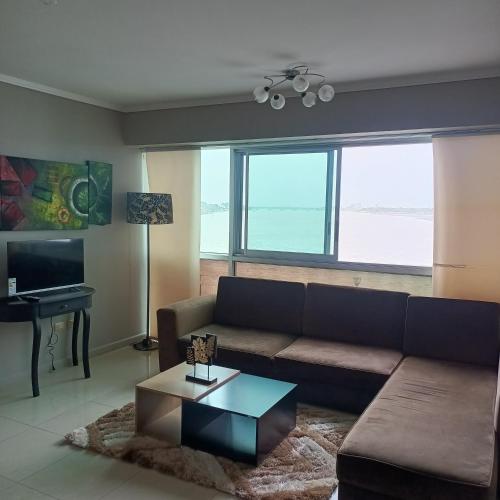 uma sala de estar com um sofá e uma mesa em 2 habitaciónes vista al río 102 em Guayaquil