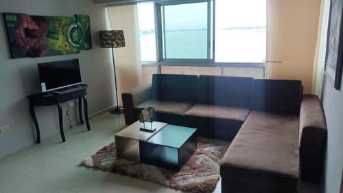 uma sala de estar com um sofá e uma mesa de centro em 2 habitaciónes vista al río 102 em Guayaquil