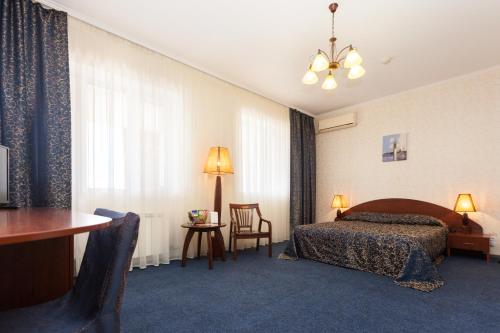 a hotel room with a bed and a table and chairs at Rahat Hotel in Aktau