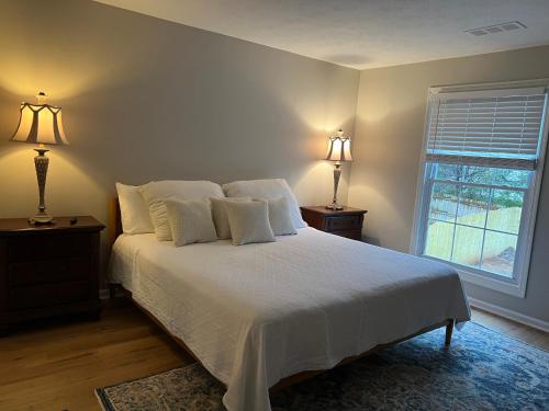 a bedroom with a bed with white sheets and a window at Mar town house in Smyrna
