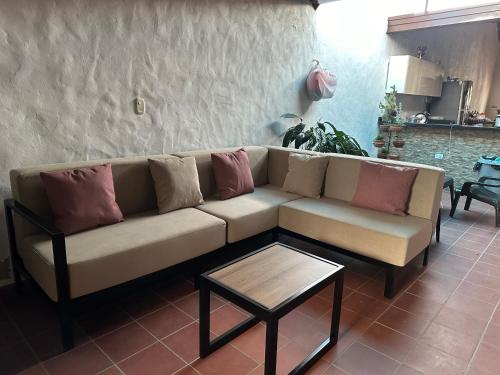 a couch with pillows on it in a living room at Casa Victoria in Zapatoca