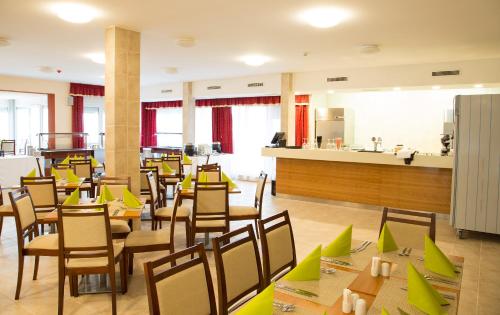 a restaurant with tables and chairs in a room at Luxury Hotel Siófok in Siófok