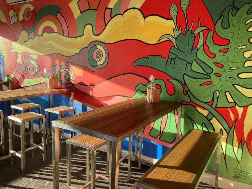 a mural on the wall of a restaurant with wooden tables at Bridport Bay Inn in Bridport