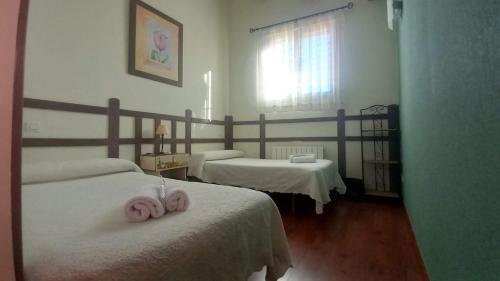 a room with two beds with pink towels on them at Casa Rural Bigotes in Arlanzón