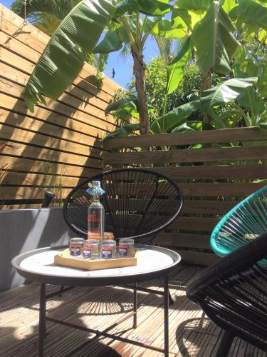 a table with a bottle of water on a chair at Villa Petite Terre à 50 mètres de la plage in Saint-François