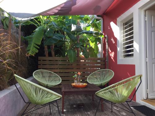 a patio with two green chairs and a table at Villa Petite Terre à 50 mètres de la plage in Saint-François