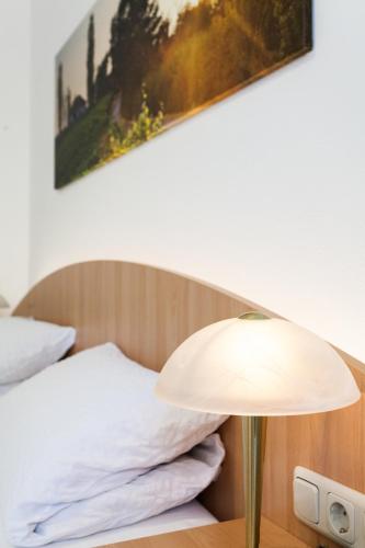 a lamp on a table next to a bed at Gästehaus Ferk - Frühstückspension, Bed & Breakfast in Bad Radkersburg