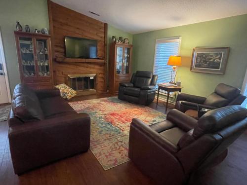 a living room with leather furniture and a fireplace at Wayne's Place-Hot tub, pet friendly. Close to HPU in High Point