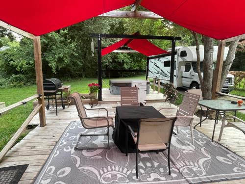 a patio with tables and chairs under a red umbrella at Wayne's Place-Hot tub, pet friendly. Close to HPU in High Point