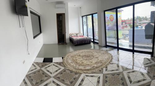 een woonkamer met een tapijt op een tegelvloer bij Calo Apartel in Panabo