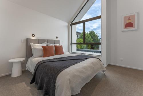 a bedroom with a bed and a large window at Urban Nest - Entire Townhouse and Free Parking in Christchurch