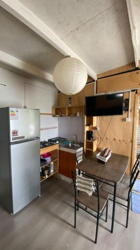 uma cozinha com uma mesa e um frigorífico em Cabaña Chaitén em Chaitén