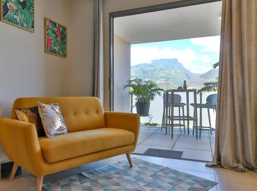 d'un salon avec un canapé et un balcon. dans l'établissement Charmant Appartement Topaze, à Papeete