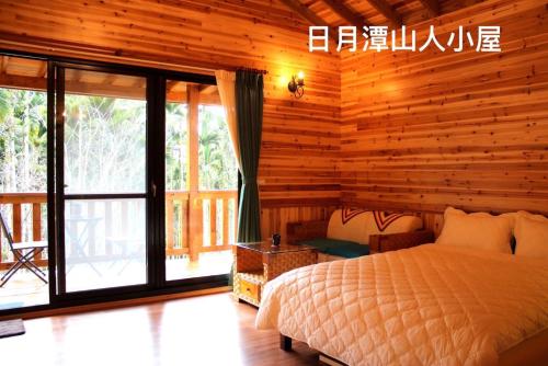 a bedroom with a bed and a wooden wall at Cabin of Sun Moon Lake in Yuchi