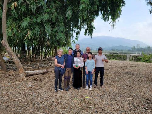 una famiglia che posa per una foto sotto un albero di Homestay tuấn bay du lịch cộng đồng a Yên Bái
