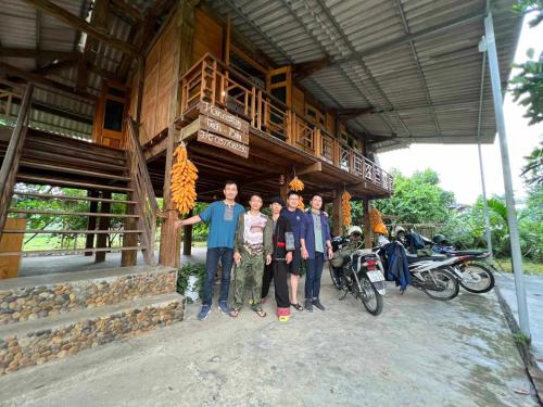 un groupe de personnes debout devant un bâtiment dans l'établissement Homestay tuấn bay du lịch cộng đồng, à Yên Bái