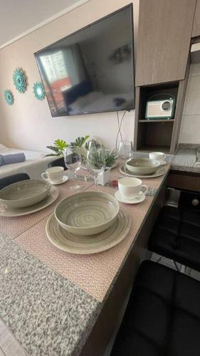 a kitchen counter with plates and glasses on it at 8 Apartamento en Santiago en fente al Metro - Hipodromo de Chile y Estadio San Laura in Santiago