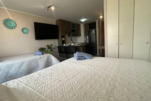 a room with two beds and a kitchen with a tv at 8 Apartamento en Santiago en fente al Metro - Hipodromo de Chile y Estadio San Laura in Santiago