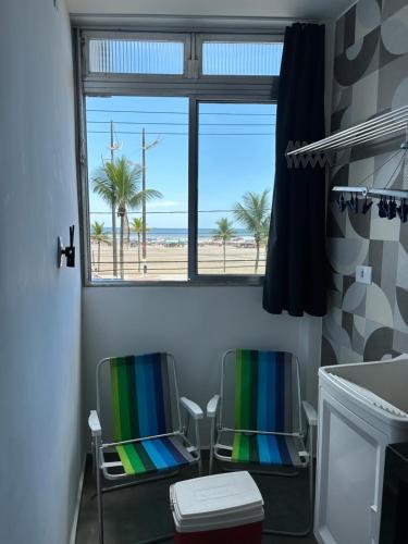 two chairs in a bathroom with a view of the beach at Pé na areia, vista mar, wi-fi e varanda ! in Praia Grande