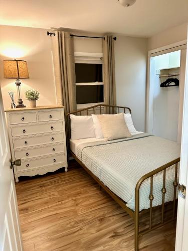 a small bedroom with a bed and a dresser at Charming and Convenient 2br 1ba apt - fully furnished and equipped - fast Internet in Forest Park