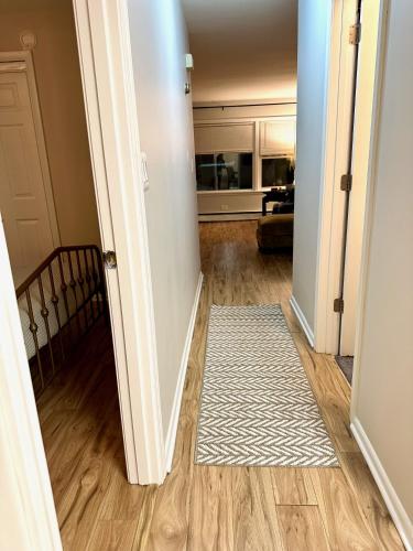 a hallway with a white rug on a hard wood floor at Charming and Convenient 2br 1ba apt - fully furnished and equipped - fast Internet in Forest Park